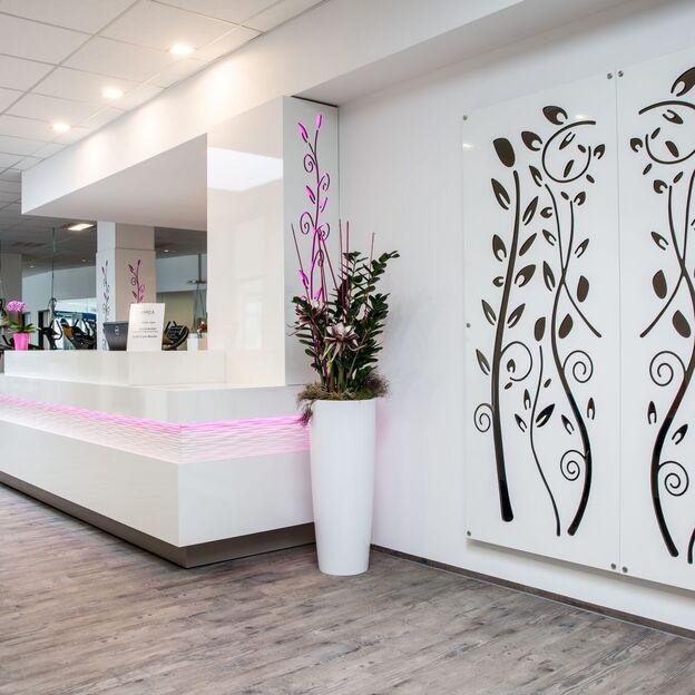 Eingangsbereich Fitnessstudio Eingangsbereich eines Fitnessstudios mit weißen Möbeln und großer Wandbemalung