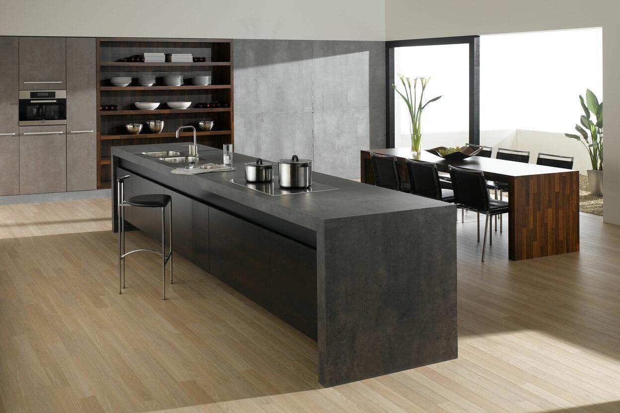 Küchen- und Esszimmerimpression mit einer Kombination aus Holz- und Stein-/ Betonoptik und Einbauschränken