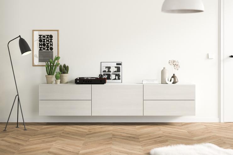 Ein maßangefertigtes, wandmontiertes Hängeboard in schlichtem Weiß, ergänzt durch zeitgenössische Deko und Grünpflanzen, fügt sich nahtlos in ein gemütliches Wohnambiente ein.